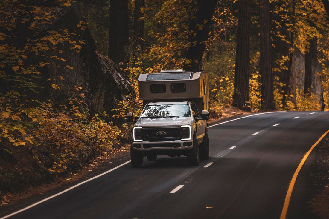 RV traveling through colorful autumn forest